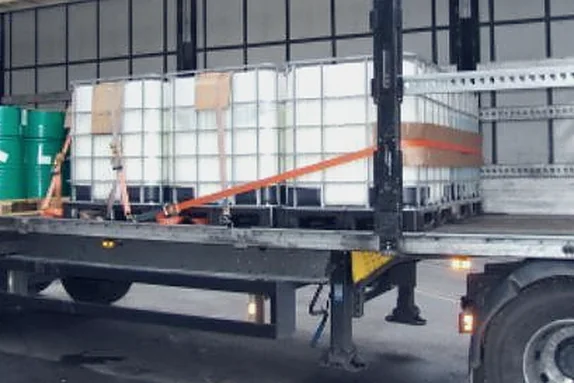 Drums and containers secured on a flatbed trailer