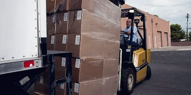 Forklift loading palletised cargo into a trailer
